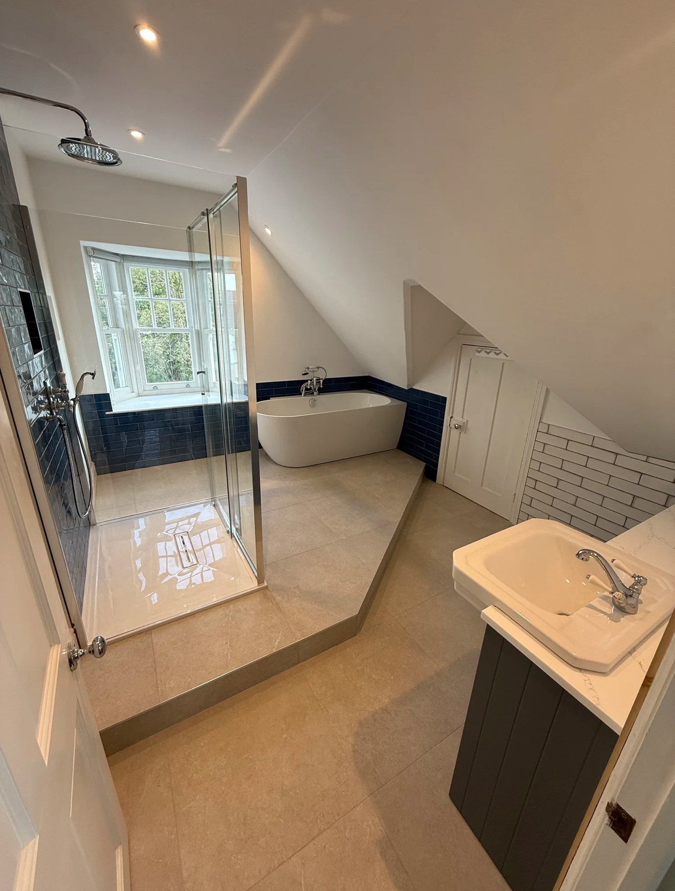 Loft bathroom conversion with navy metro tiles, freestanding bath and walk-in shower — Basingstoke